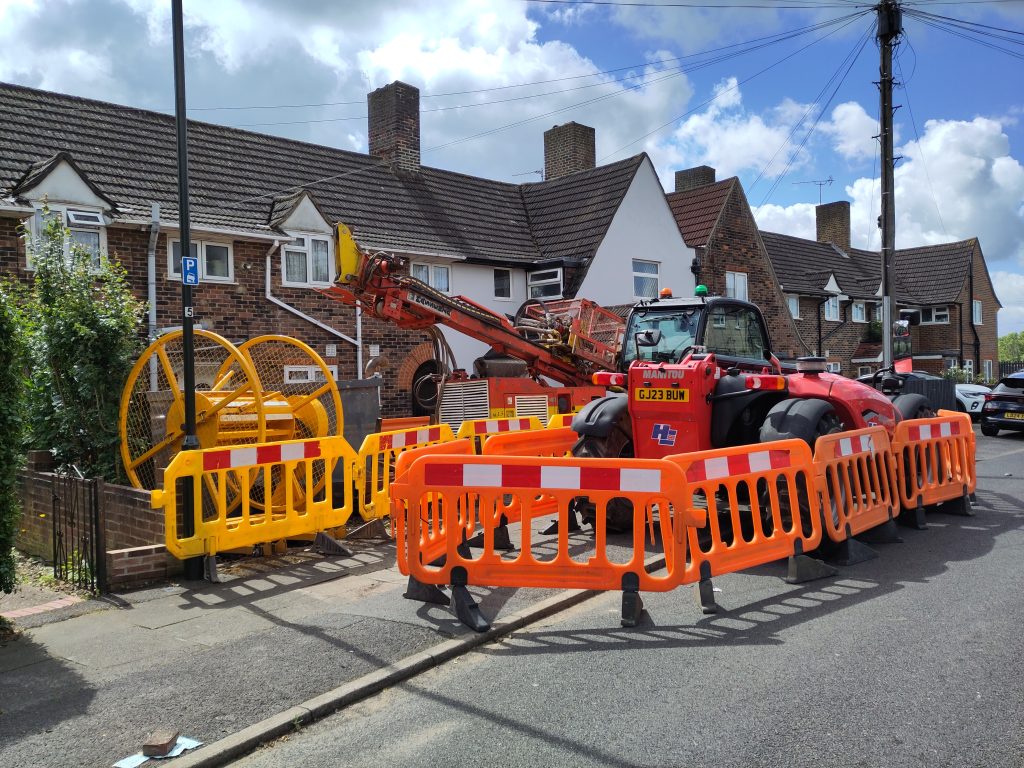 A machine digging bore holes in the front garden of a London home.